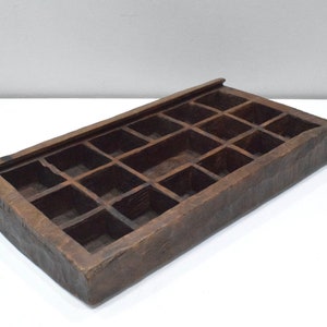 Op de afbeelding: Een houten dienblad met 16 vakken. Het dienblad is gemaakt van donkerbruin hout en heeft een rustieke uitstraling.