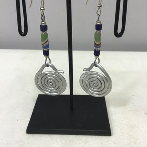 May include: Silver spiral earrings with blue and green glass beads hanging from silver hooks.
