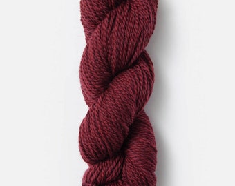 Puede incluir: Un ovillo de lana de color rojo oscuro.