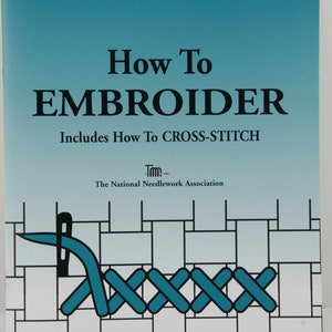May include: Book cover with a blue background and the title "How To EMBROIDER Includes How To CROSS-STITCH" in black text. The National Needlework Association logo is below the title. The cover also features a blue illustration of a needle and thread stitching a cross-stitch pattern.