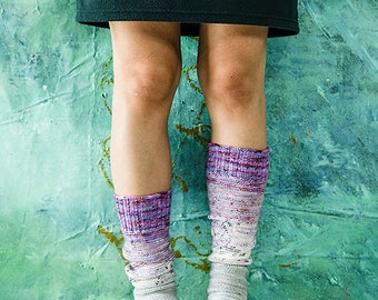 May include: A pair of colorful knee-high socks with a gradient pattern of purple, white, and blue. The socks are made of a soft, knitted fabric.