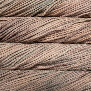 May include: Close-up of several skeins of yarn. The yarn is a blend of light brown, tan, and muted green colors. The texture of the yarn is clearly visible, with each strand tightly twisted. The overall appearance suggests a natural, earthy aesthetic, suitable for knitting or crochet projects.