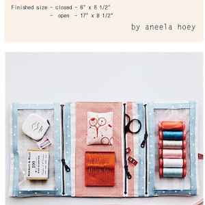 May include: Open sewing pouch with various sewing supplies. The pouch is blue and white with a zipper closure. Contents include thread spools, scissors, needles, pins, and a measuring tape. The text "Make And Go Pouch" is at the top.