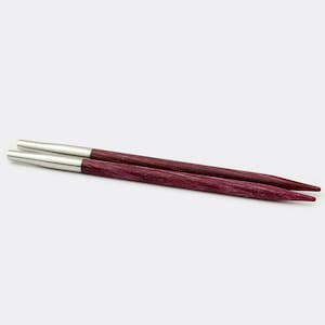 May include: A pair of purple wooden knitting needles with silver tips.