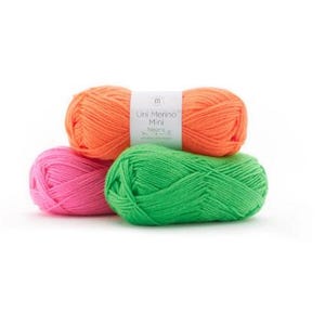 May include: Three balls of yarn in pink, green, and orange. The orange ball has a label that reads "Un Merino Mix" with a small logo.