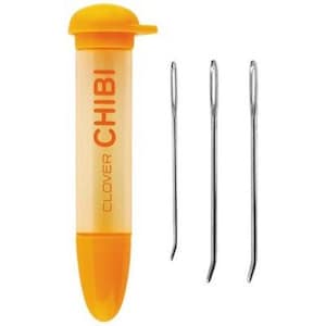 May include: A set of three Clover Chibi needles in a bright orange plastic case. The needles are thin and sharp, perfect for sewing small projects.