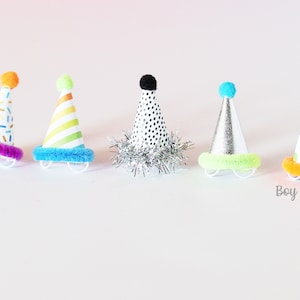 May include: Five colorful party hats with different patterns and pom-poms on top. The hats are arranged in a row on a white surface.  "Boy Sample" is written in black text at the bottom of the image.