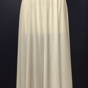 May include: A white, full-length slip skirt with a gathered waistband.