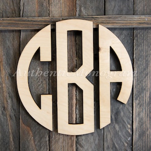 Peut inclure: Un monogramme en bois avec les lettres "CRA" découpées en cercle. Le monogramme est en bois clair et a une finition naturelle.