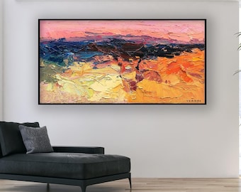 Puede incluir: Pintura al óleo de paisaje abstracto en un marco negro. La obra presenta una escena texturizada y colorida con tonos de amarillo, naranja, azul y rosa. La pintura cuelga sobre un chaise longue negro en un salón moderno.