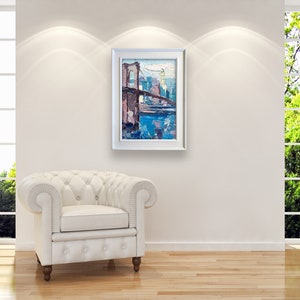 An original framed painting of the Brooklyn Bridge with cityscape of New York in the background. The painting is in shades of blue, purple, and brown.