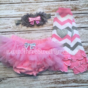 May include: Pink tutu skirt with a silver bow, pink and gray chevron leg warmers with a silver heart, and a gray flower headband with a pink bow.