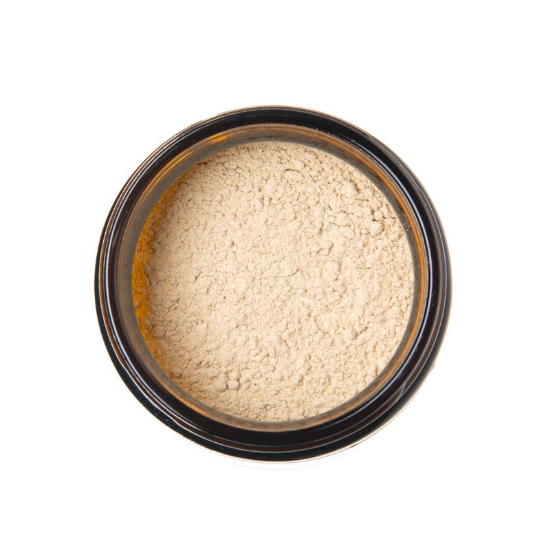 May include: A small glass jar with a brown lid filled with a light beige powder.