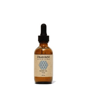 May include: A brown glass bottle of nose oil with a black dropper. The label reads "PAAVANI AYURVEDA" and "NOSE OIL nasya 2 fl. oz." The label has a geometric design in the center. The bottle is set against a white background.