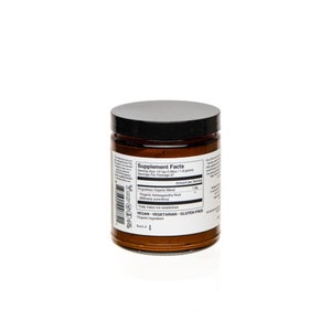 Puede incluir: Un frasco de vidrio marr&oacute;n con tapa negra que contiene un polvo de suplemento. La etiqueta dice "Supplement Facts" y enumera los ingredientes como "Proprietary Organic Blend" y "Organic Ashwagandha Root (Withania somnifera)". La etiqueta tambi&eacute;n dice "Vegan - Vegetarian - Gluten Free".