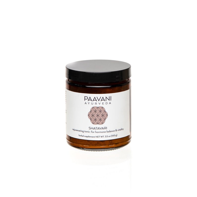 May include: A brown glass jar with a black lid containing Shatavari powder. The label reads "PAAVANI AYURVEDA" and "SHATAVARI rejuvenating tonic for hormone balance & vitality herbal supplement NET WT. 3.5 oz (100 g)".