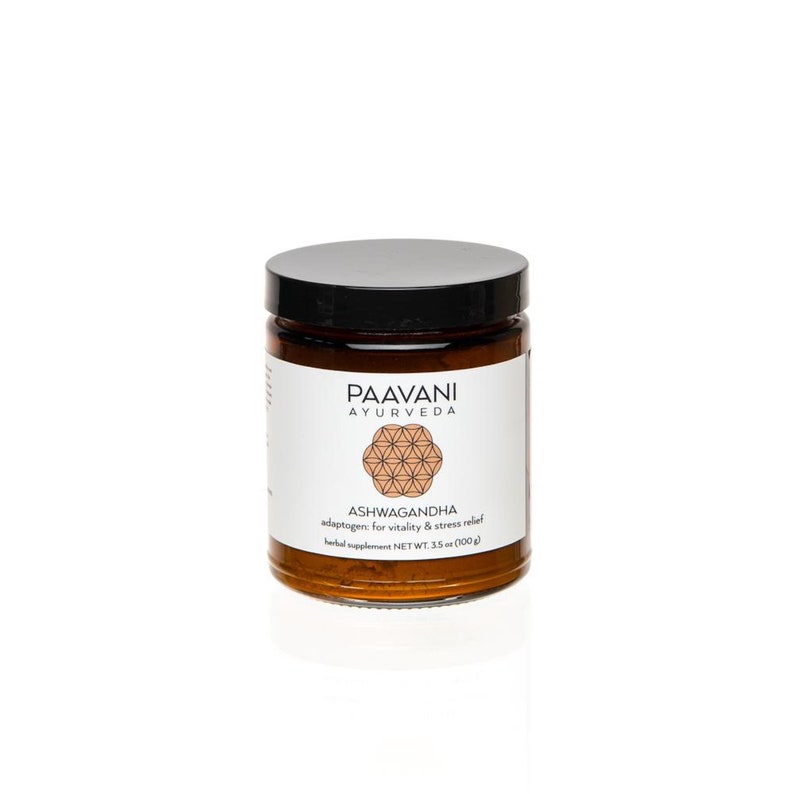 Puede incluir: Un tarro de vidrio marr&oacute;n con tapa negra que contiene un polvo marr&oacute;n. La etiqueta dice "Paavani Ayurveda" y "Ashwagandha adapt&oacute;geno para la vitalidad y el alivio del estr&eacute;s" con un peso neto de 3,5 oz (100 g).
