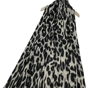 May include: A gray and black leopard print scarf with a pleated texture.