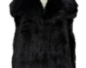 May include: A black faux fur vest with a V-neck collar. The vest is sleeveless and has a soft, textured appearance. The garment is displayed on a mannequin.