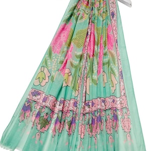 Peut inclure: Écharpe légère ornée d'un motif floral dans les tons turquoise, rose et vert. Le motif répété présente de grandes fleurs roses et de plus petits motifs floraux, créant un accessoire vibrant et féminin.
