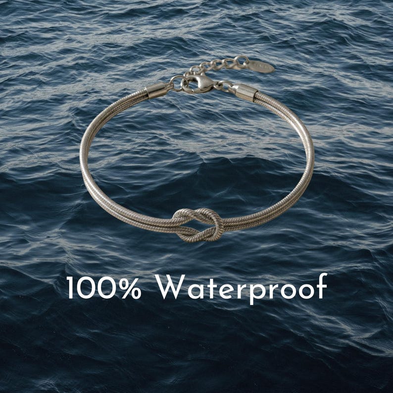 May include: Silver-toned bracelet with a knot design, set against a backdrop of blue water. The bracelet is made of a woven material and features a clasp closure. Text on the image reads "100% Waterproof".