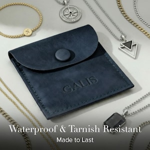 May include: A navy blue leather pouch with the embossed word "GALIS" is the focal point of this image. Various necklaces and a bracelet surround the pouch. The text "Waterproof & Tarnish Resistant" and "Made to Last" are at the bottom.