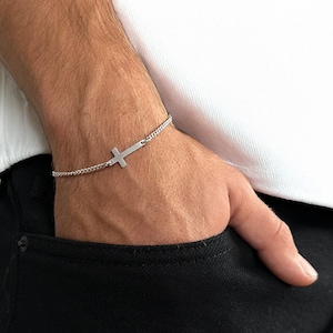 以下が含まれることがあります： シンプルな十字架のペンダントが付いたシルバーチェーンブレスレット