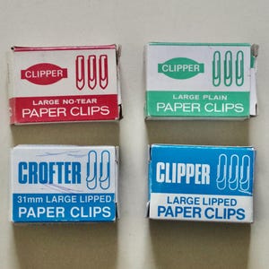May include: Four rectangular boxes of paper clips. Top left is red and white labelled CLIPPER LARGE NO-TEAR PAPER CLIPS. Top right is green and white labelled CLIPPER LARGE PLAIN PAPER CLIPS. Bottom left is blue and white labelled CROFTER 31mm LARGE LIPPED PAPER CLIPS. Bottom right is blue and white labelled CLIPPER LARGE LIPPED PAPER CLIPS.