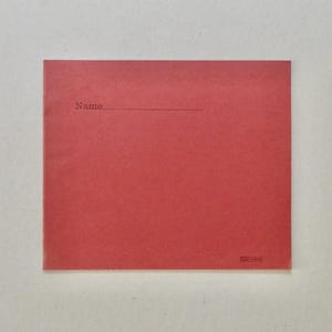 May include: A red square card with the word "Name" printed in a small, dark font above a horizontal line. The card has a simple, minimalist design and a small logo in the bottom right corner.