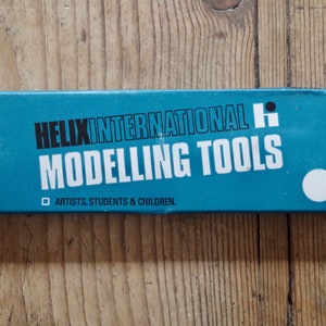Może przedstawiać: Niebieskie pudełko z białym napisem "HELIX INTERNATIONAL H MODELLING TOOLS" i "ARTISTS, STUDENTS & CHILDREN."