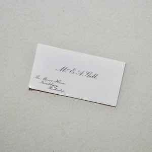 Pode incluir: Um cart&atilde;o de visita branco com o nome "Mr. E. A. Gill" em escrita elegante. Abaixo do nome, o cart&atilde;o lista "The Manor House, Frindsbury, Rochester" em uma fonte menor.