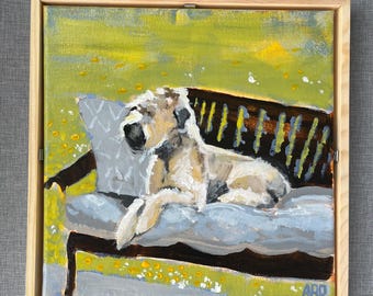 Könnte beinhalten: Ein Gemälde eines Hundes, der auf einem blauen Sofa mit einem weißen Kissen liegt. Der Hund ist weiß und grau mit einer schwarzen Nase. Der Hintergrund ist ein grünes Feld mit gelben Blumen.
