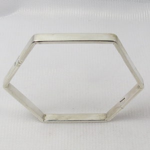 Peut inclure: Un bracelet hexagonal en argent avec une ouverture à charnière.
