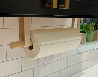 Le porte-serviettes suspendu est une alternative moderne au support de comptoir qui se monte sous le meuble avec des lanières de cuir et du bois de bouleau ou de noyer