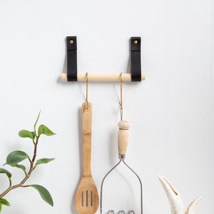 A Hanging Dowel Kit installed on the wall with kitchen accessories hanging.