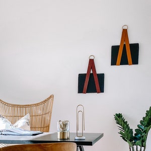 Home office setting with a desk and leather file holders displayed on the wall to the right.