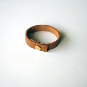 Caramel-toned leather loop in the Nicotine finish, made by keyaiira from smooth full-grain leather with brass hardware.