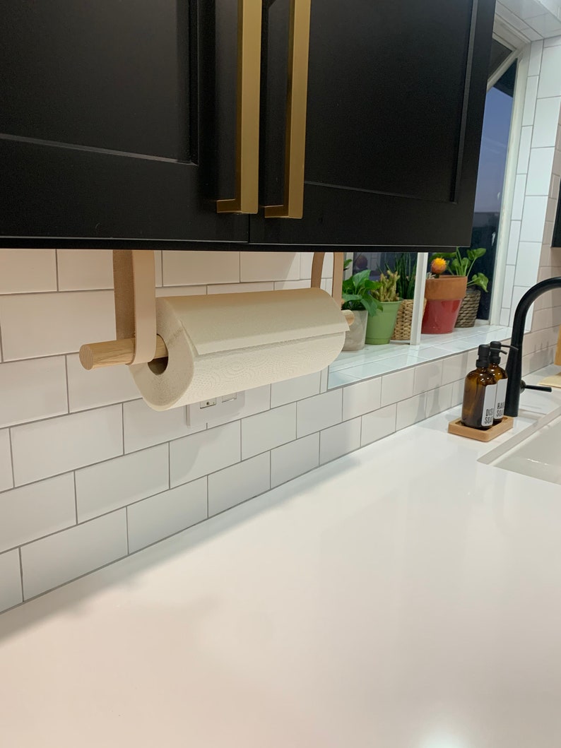 A Paper Towel Holder installed under a cabinet in a kitchen.