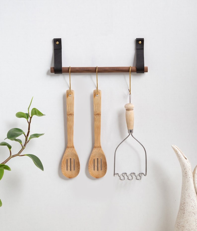 A Hanging Dowel Kit installed on the wall with kitchen accessories hanging.