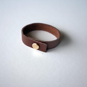 Medium brown Walnut leather loop made from supple full-grain leather with a modern brass screw closure detail handmade by keyaiira