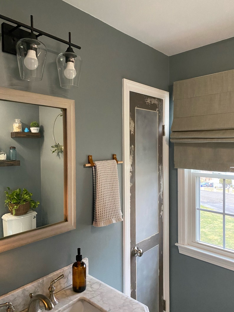 A wooden dowel used to hang a towel in a bathroom.