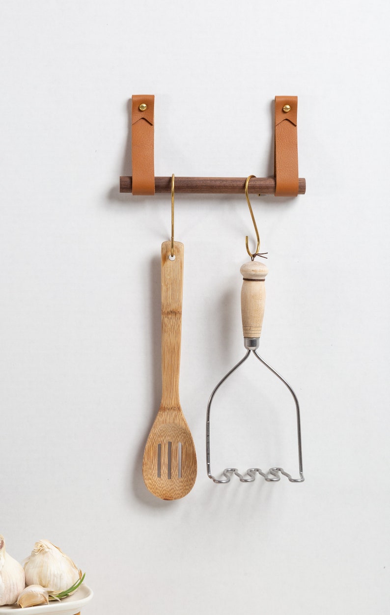 A Hanging Dowel Kit installed on the wall with kitchen accessories hanging.