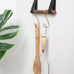 A Hanging Dowel Kit installed on the wall with kitchen accessories hanging.