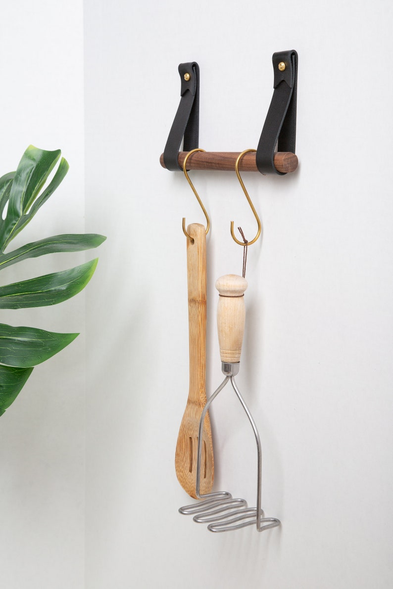 A Hanging Dowel Kit installed on the wall with kitchen accessories hanging.