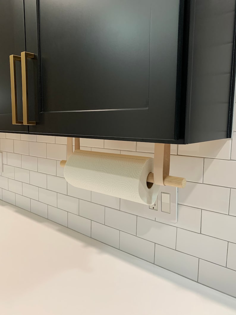 A Paper Towel Holder installed under a cabinet in a kitchen.