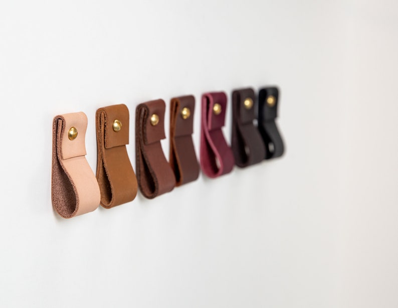 A row of installed wall straps lined up on a wall displaying all available colors.