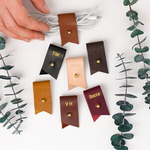 Small Leather Cord Holders displayed on a white background displaying available colors.