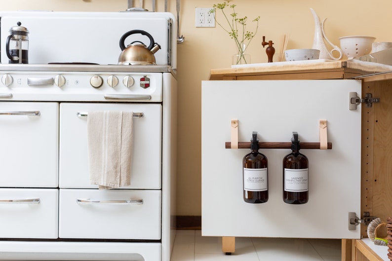 A kitchen scene of a Cabinet Rail Kit installed under the sink on a cabinet door.