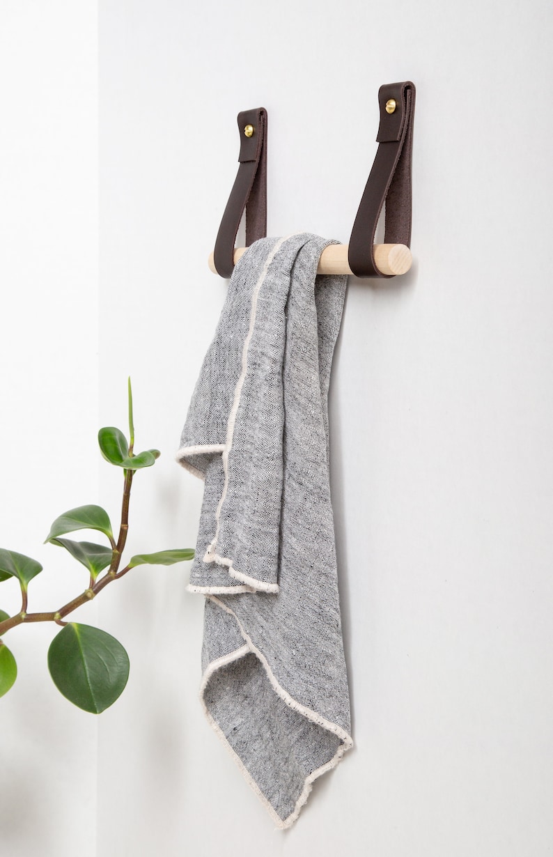 A Hanging Dowel Kit installed on the wall with a towel hanging.