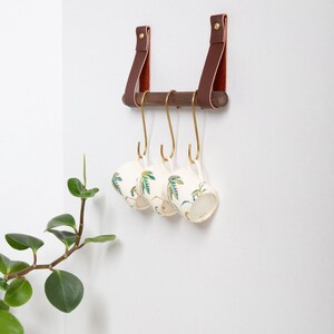 A Hanging Dowel Kit installed on the wall with mugs hanging.